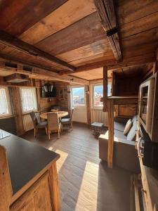 a living room with a bed and a dining room at Cuore Tana dell'Orso in Campitello di Fassa