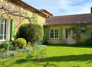 a green house with a table in the yard at Le Relais Notre Dame in Quinson