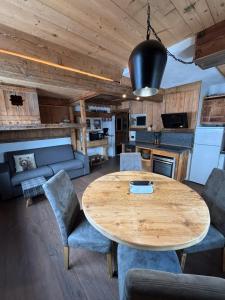 a kitchen and dining room with a wooden table and chairs at Cuore Tana dell'Orso in Campitello di Fassa