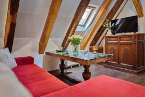 a living room with a red couch and a table at Hotel Svambersky dum in Český Krumlov