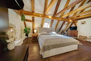 a bedroom with a large bed and wooden ceilings at Hotel Svambersky dum in Český Krumlov