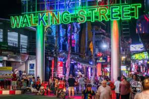 a busy city street with a walking street sign at The One Hotel in Pattaya