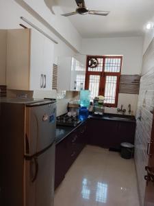 a kitchen with a refrigerator and a stove at Esadan in Agra +7 photos