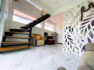 a living room with stairs and a wall with a tree mural at MulBerry Villa in Kandy
