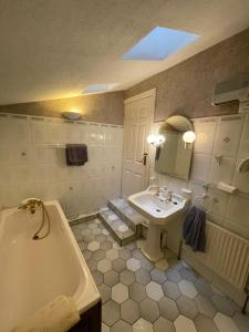 a bathroom with a tub and a sink and a bath tub at Riverside Guesthouse in Charlestown