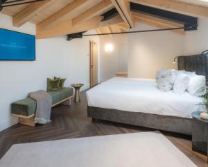 a bedroom with a large bed and a chair at The Castelletto - Boutique Hotel in Montebelluna