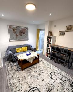 a living room with a couch and a table at Entire Apartment Bright & Spacious with Private Garden Near Victoria Park in London