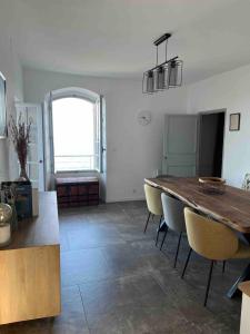 a dining room with a wooden table and chairs at Large period house with panoramic view in Canari