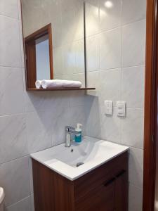 a bathroom with a sink and a mirror at KC Suites in Comitán