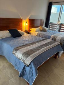 two beds sitting next to each other in a bedroom at KC Suites in Comitán
