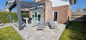 a patio with chairs and a table in a yard at Vakantiehuis Vinkeveen in Vinkeveen