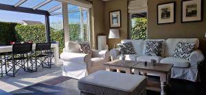 a living room with white furniture and a table at Vakantiehuis Vinkeveen in Vinkeveen +11 photos