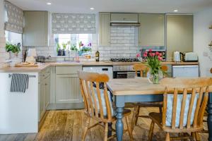 a kitchen with a wooden table with chairs and a counter at 2 Bed in St Helens oc-76608 in Brading