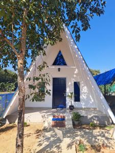 a triangular house with a tree in front of it at Mung Kham Stays in Jorhat