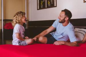 a man and a woman sitting on a bed at Hotel Calimera in Santa Teresita +57 photos