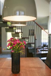 a vase filled with pink flowers sitting on a table at Oak Lodge in Knighton