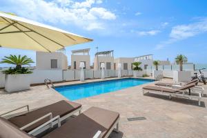 a swimming pool with chaise lounge chairs and an umbrella at Villa Sol in Orihuela Costa