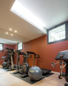 a gym with tread machines and a mirror at The Castelletto - Boutique Hotel in Montebelluna