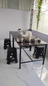 a table with plates and pans on top of it at Joseph's Residency Homestay in Podanūr