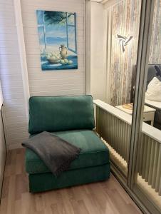 a green chair in a room with a window at Seehütte 004 in Cuxhaven +12 photos