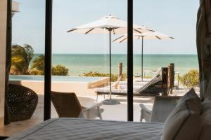 a room with a view of the beach and the ocean at Beach House Costa Yucatan by Trobbu Collection in Xtampú