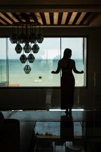 a woman is standing in front of a window at Beach House Costa Yucatan by Trobbu Collection in Xtampú