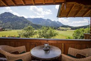 una mesa y sillas en un porche con vistas a las montañas en Ferienwohnungen Haus Martin, en Inzell