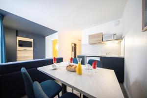 a room with a table and chairs and a kitchen at City Résidence Nancy in Nancy