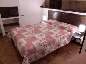 ein Schlafzimmer mit einem Bett mit einer rot-weißen Decke in der Unterkunft Le 5 querce in Nettuno