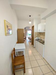 a kitchen with a table and a bench in a room at Villa Anna Maria in Agia Paraskevi