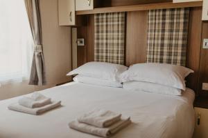a large white bed with two towels on it at Upper Cliff 2 in Easton
