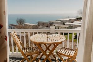 a wooden table and two chairs on a balcony at Upper Cliff 2 in Easton