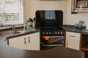a kitchen with a sink and a stove top oven at Upper Cliff 2 in Easton