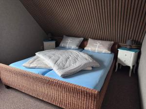 a bedroom with a wicker bed with two pillows at FeWo Fuhrmann in Bensersiel