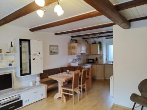 a kitchen and living room with a table and chairs at "Ferienhaus-Ottendorf" mit Pool und Infarotkabine in Ottendorf