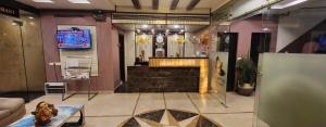 a lobby with a staircase and a television in a building at Hotel Cosmos in Lucknow