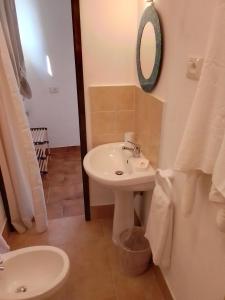 ein Badezimmer mit Waschbecken und Spiegel in der Unterkunft Le 5 querce in Nettuno + 2 Fotos