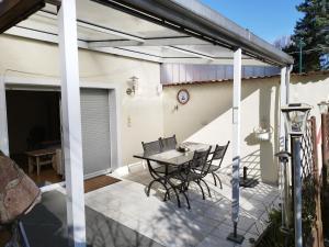 a patio with a table and chairs on it at "Ferienhaus-Ottendorf" mit Pool und Infarotkabine in Ottendorf
