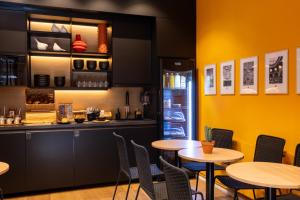 ein Restaurant mit Tischen, Stühlen und einer Theke in der Unterkunft Korner République in Paris