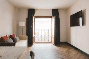 a living room with a couch and a large window at Honest Granada Apartments in Granada