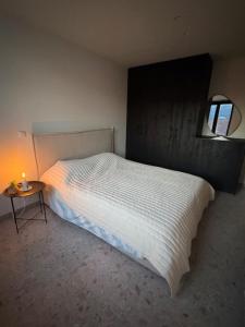 a bedroom with a white bed and a small table at The Corner-MARGO in Beernem