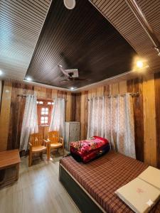 a bedroom with a bed and a table and chairs at Peace Forest Retreat in Gopeshwar
