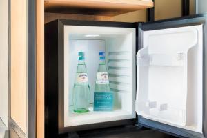an open refrigerator with two bottles of water in it at Premier Inn München City Schwabing in Munich