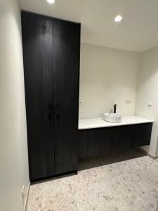 a bathroom with a black cabinet and a sink at The Corner-MARGO in Beernem +16 photos