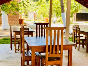 a wooden table and chairs in an outdoor area at OM Inn in Trincomalee