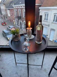 a table with a bottle of wine and a candle at The Corner-MARGO in Beernem