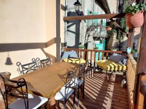 a wooden table and chairs on a balcony at CHAMBRES D'HOTES L'ANTONIN in Saint-Antoine