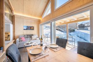 a kitchen and living room with a table and chairs at Tiny Barrhorn in Grächen