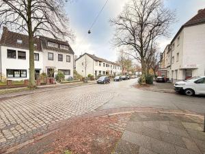 a cobblestone street with cars parked on the street at Emmas FEWO in Bremen
