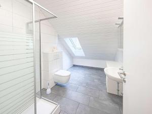 a white bathroom with a toilet and a sink at Emmas FEWO in Bremen +17 photos